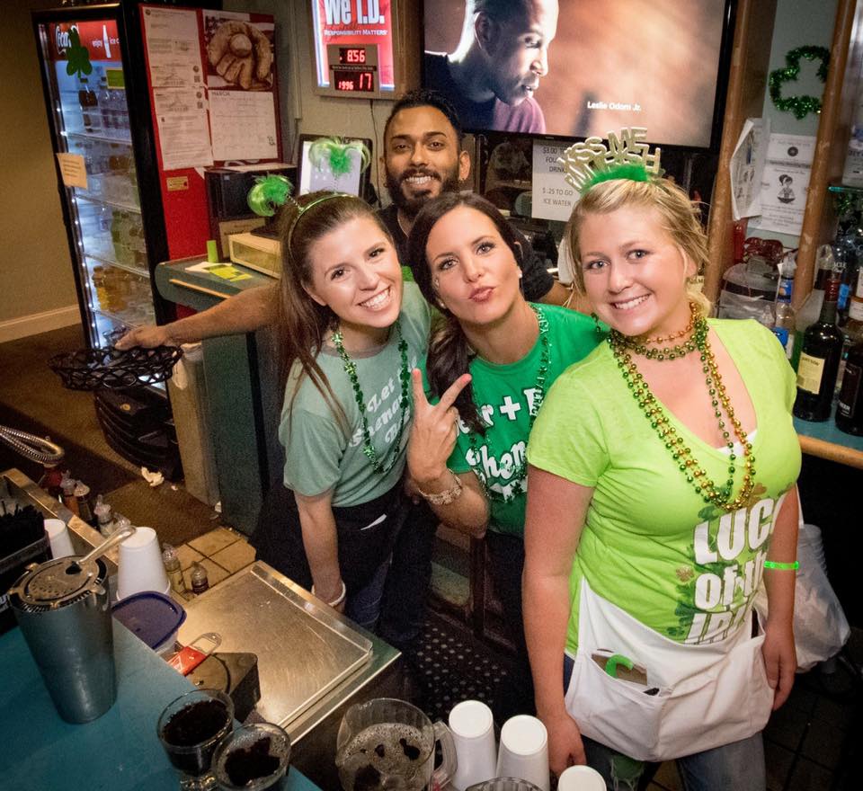 3 girls and a guy smiling for the camera in St. Patrick's day attire.